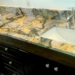 granite bathroom counter with running water from faucets