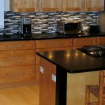 wooden kitchen cabinets, granite counters, and a refrigerator