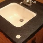 Inlaid 100 year old silver dollar into absolute black granite bathroom counter