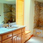 Full granite slab tub walls, tub deck and surround, matching granite counters with undermount sinks