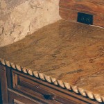 Hand carved granite rope edge along entire counter, hand scribed granite along stone wall