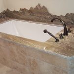 hand-carved backsplash with seamless one-piece undermount tub deck